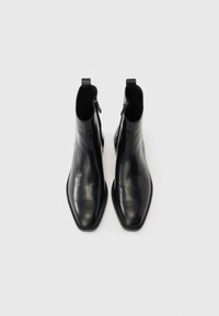 Mustad nahast pahkluu saabid terava nina, siledapinnalise tekstuuri, külgsete tõmblukkude ja minimalistliku disainiga. Tasased tallad ja tagaküljel tõmbetasked.