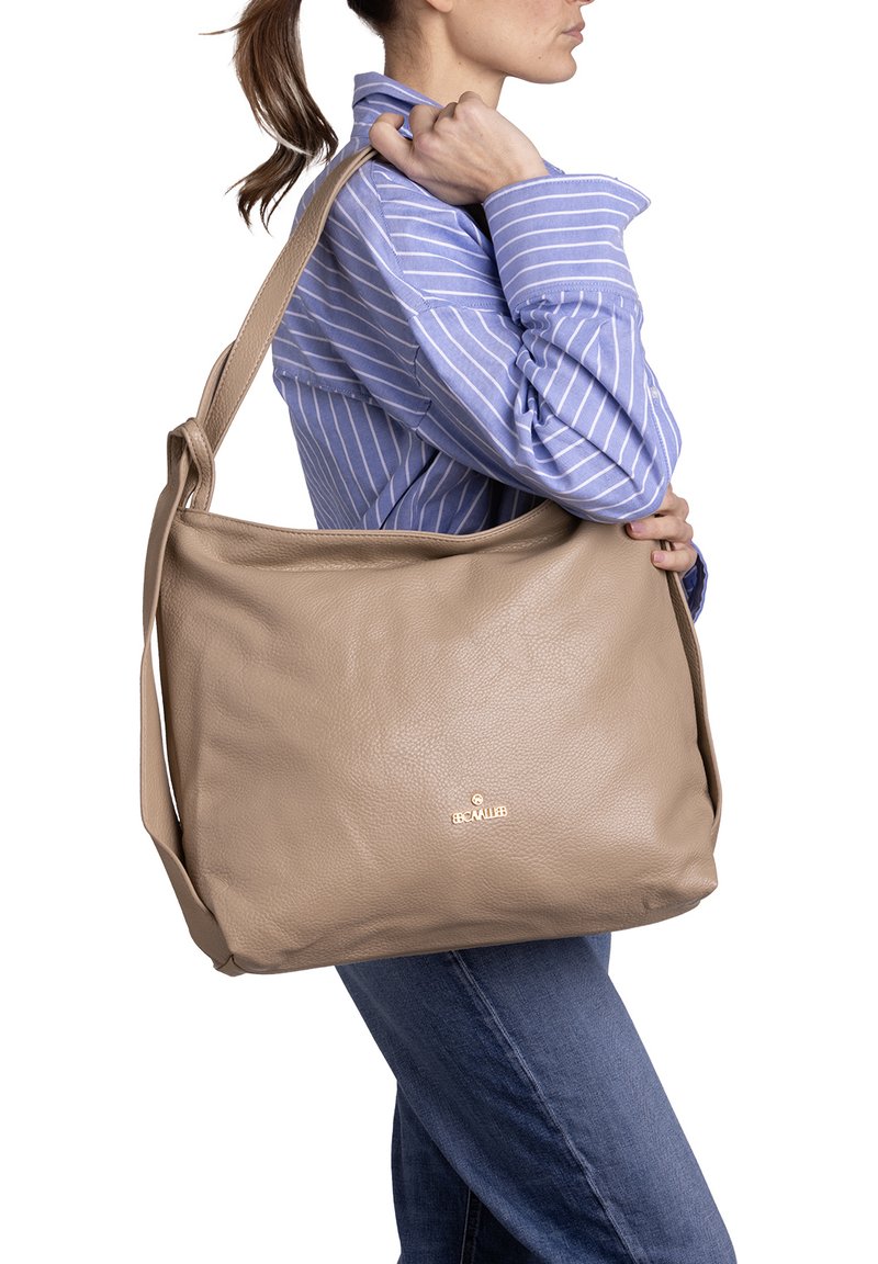 Beige leren schoudertas met textuurafwerking, groot hoofdcompartiment, gouden logo-accent en een enkele verstelbare schouderband.