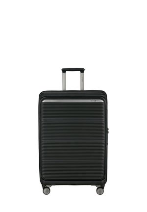 Black hard-shell suitcase with horizontal ridges, four wheels, and a fully extended telescopic handle.