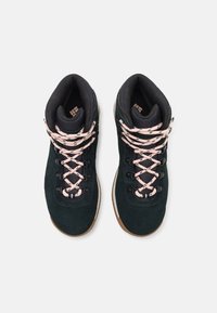 Tmavě zelené semišové turistické boty s růžovými tkaničkami, černým síťovaným límcem a gumovou podešví. Obsahují háčky pro bezpečné šněrování.