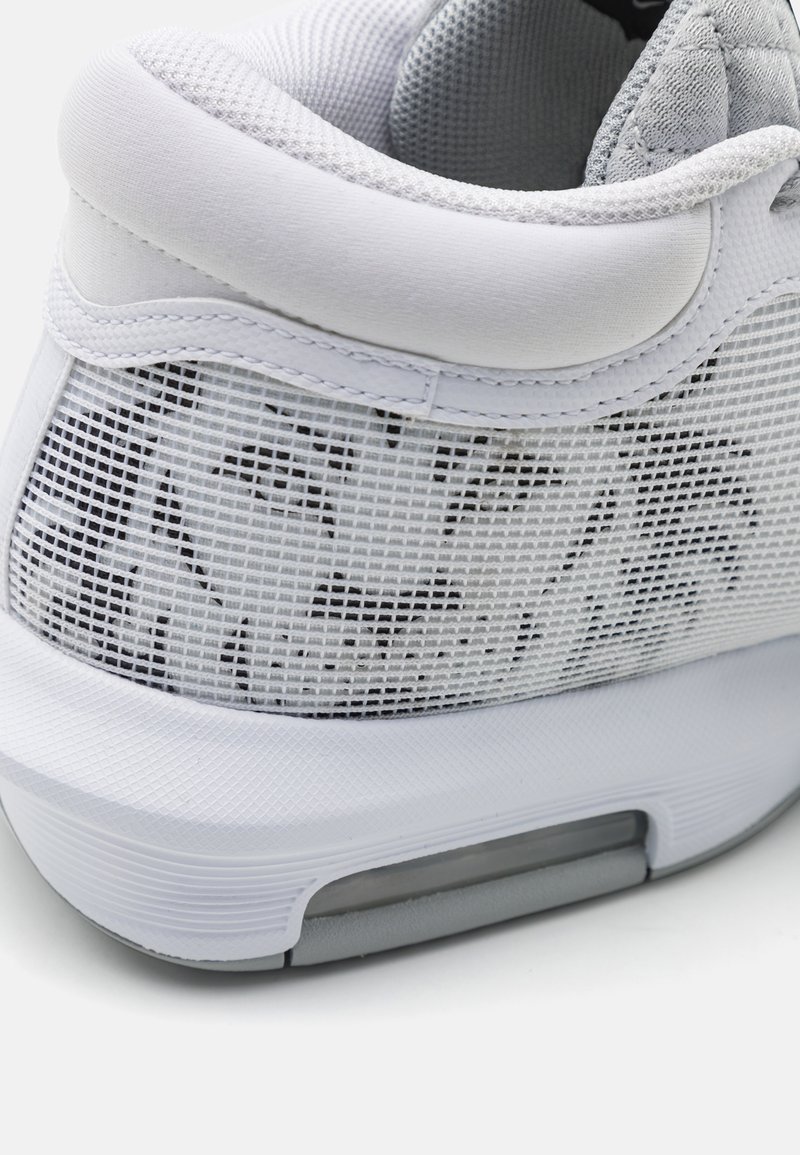 Zapatilla deportiva blanca con una parte superior de malla texturizada con un patrón de rejilla, puntera redondeada y acentos grises en la entresuela y el talón.