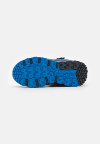 Blue and black athletic shoe sole featuring a textured, rugged pattern for traction, made from rubber material with molded designs.