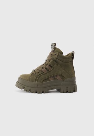 Green suede ankle boots with a rugged rubber sole, featuring a lace-up design and camo accents, delivering a textured, sporty look.