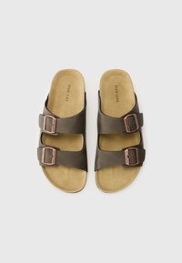 Brune lær sandaler med to justerbare spænder, blødt beige fodseng, åbent tådesign, flad sål og minimalistisk stil.
