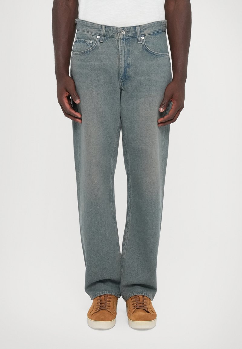 Ljust grå denimjeans med en avslappnad passform, med klassisk femficksdesign och metalldetaljer, ihop med bruna mockaskor.