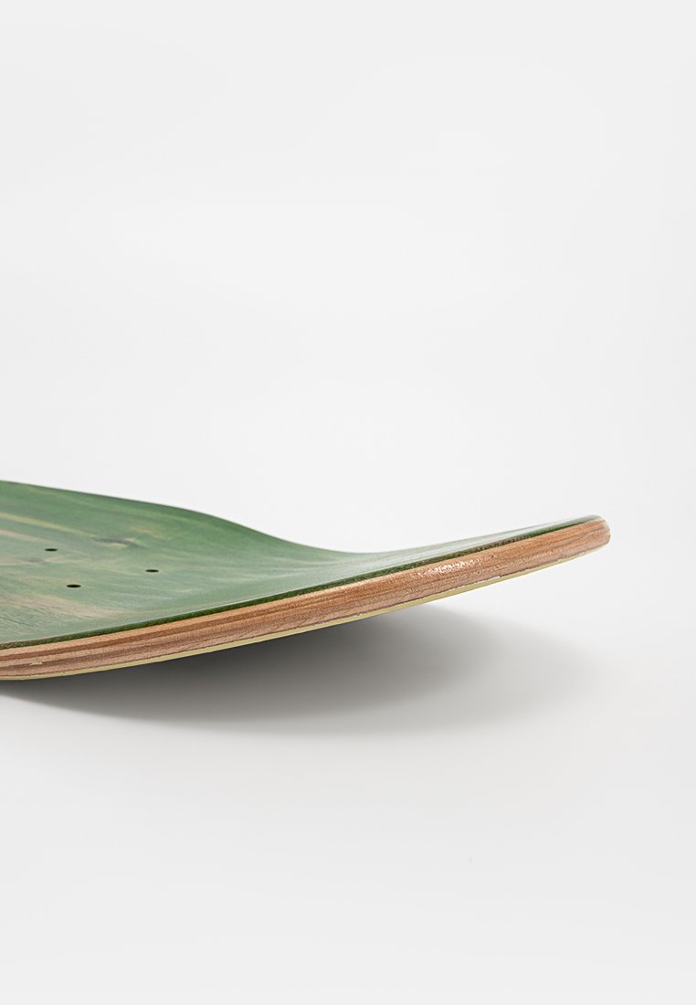 Plateau de skateboard en bois avec une finition verte, forme courbée, bords en bois naturel et plusieurs découpes pour l'attache du matériel.