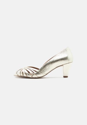 Zlatna ženska sandala s niskom petom, otvorenih prstiju i s više tankih remenčića preko prednjeg dijela, s teksturiranim metalik završetkom.