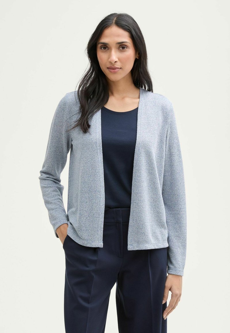 Ljusblå cardigan med mjuk textur, öppen framdesign, långa ärmar och matchad med en mörk marinblå topp och skräddarsydda marinblå byxor.