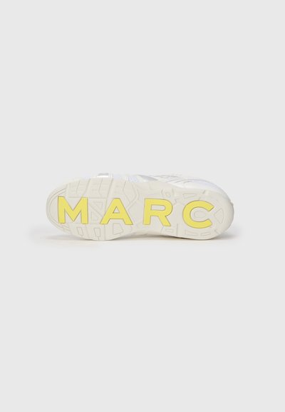 Talpă de sneaker albă cu un model texturat; "MARC" în litere îngroșate de culoare galbenă. Design simplu și modern, cu un aspect robust.