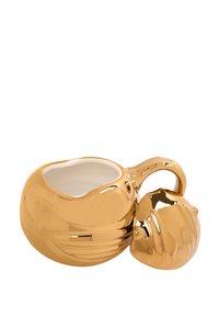 Tazza in ceramica dorata con superficie liscia e lucida e interno bianco. Presenta un manico stilizzato che somiglia a una conchiglia.