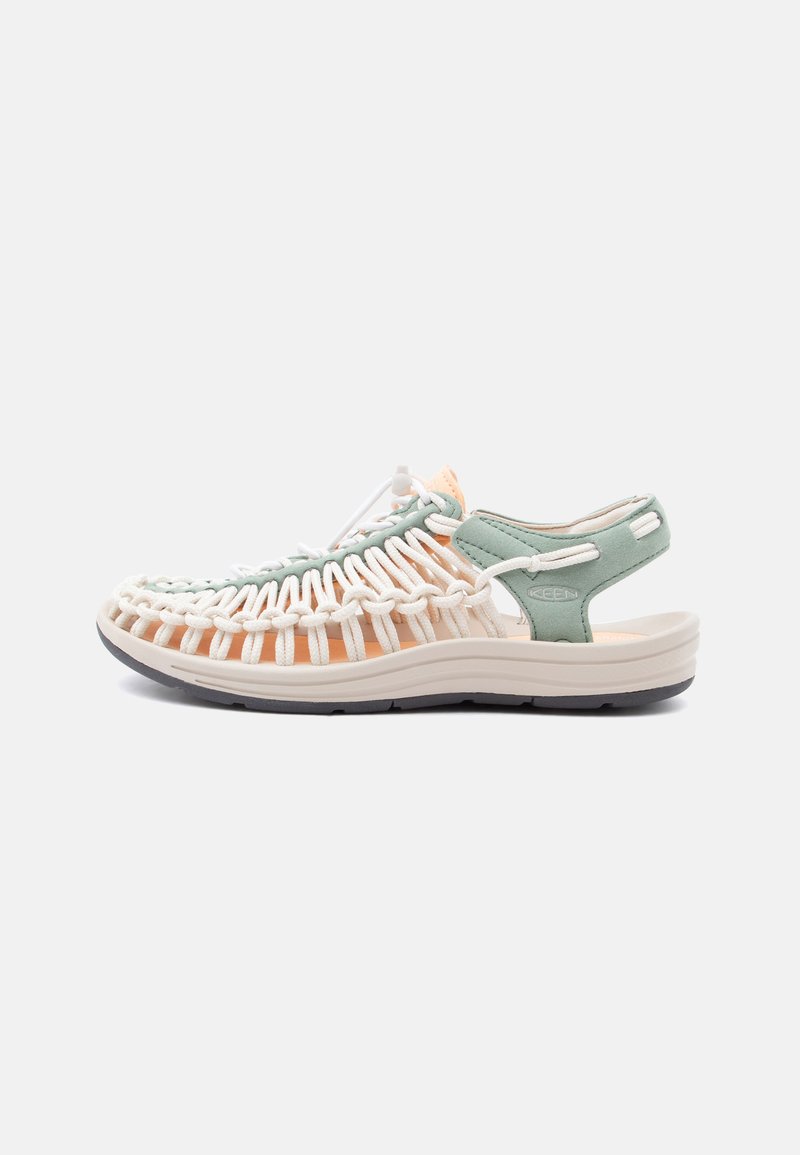 Ανοιχτό πεδιλάκι σε ανοιχτό πράσινο και μπεζ, με πλεκτό κορδόνι στο πάνω μέρος, μαλακή σόλα, ρυθμιζόμενο κορδόνι και λουράκι στο πίσω μέρος για ασφαλή εφαρμογή.