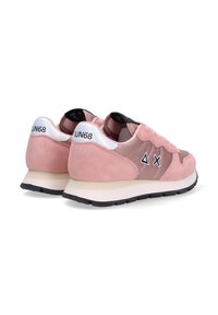 Różowe zamszowe sneakersy z gładką beżową podeszwą, z czarnymi akcentami i logo. Projekt zawiera mieszankę tekstur i kontrastowych detali.