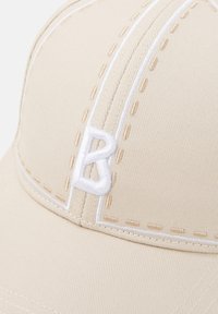 Beige Stoff-Baseballmütze mit weißer Stickerei und einem erhabenen weißen "B"-Logo auf der Vorderseite. Strukturierte Form mit strukturiertem Finish.