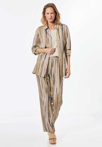 Lichtgewicht, gestreepte blouse en bijpassende broek in tinten van beige, bruin en grijs met een ontspannen pasvorm. Natuurlijke vezelstructuur en knoopdetails.