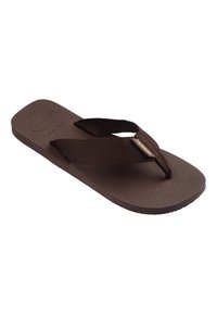 Sandale tongs en caoutchouc marron avec semelle texturée et larges brides en tissu, dotée d'une petite étiquette rectangulaire de marque sur la bride.