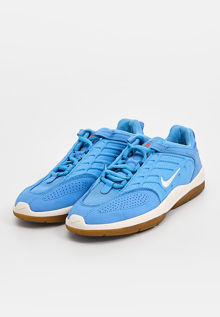 Zapatillas deportivas azules con un upper texturizado, que presenta materiales de malla y ante. Swoosh blanco de Nike y suela de goma natural. Diseño de cordones.