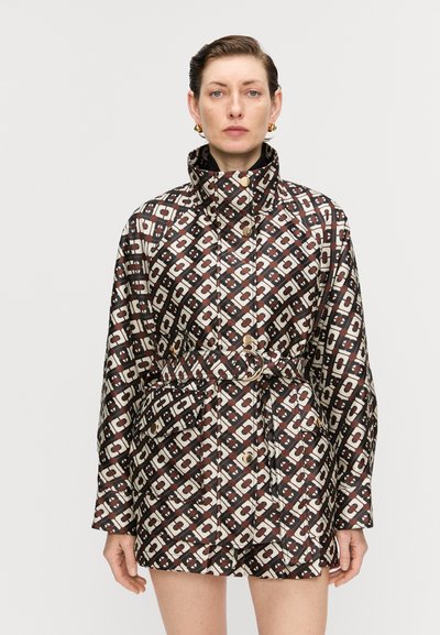 Bedruckte Jacke in Braun, Creme und Schwarz, mit hohem Kragen, tailliertem Gürtel, oversize Schnitt und Fronttaschen mit goldenen Akzenten.