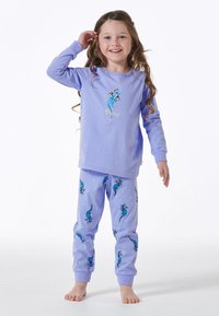 Lila Pyjama-Set mit einem Langarmoberteil, das "Dream" und eine stilisierte Delfin-Grafik zeigt; passende Hosen mit Delfin-Muster und Sternen.