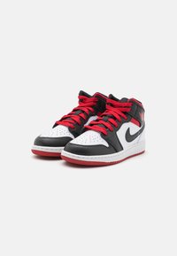 Černobílé kotníkové tenisky s červenými šněrovadly, s perforovanou špičkou, polstrovaným límcem a červenou podrážkou. Logo na boku.