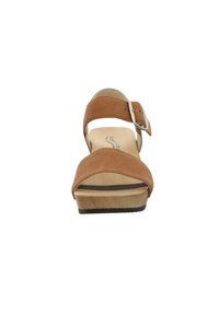 Sandale en daim marron avec une large sangle sur le pied, boucle réglable et semelle en bois plateforme. Présente une base plate texturée.