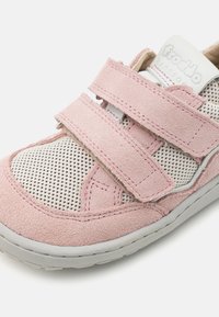 Rosa semskesneakers med meshpaneler, med to justerbare borrelåser og en grå gummisåle, designet for pusteegenskaper og komfort.