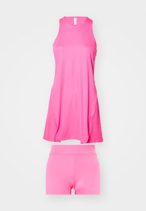 Robe de sport rose avec un design sans manches et un col rond, associée à un short ajusté assorti. Fabriquée en tissu léger et lisse.