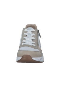 Hellbeige und weiße Sneaker mit einer strukturierten Oberfläche, flachen Schnürsenkeln, seitlichem Reißverschluss und Gummisohle, von vorne betrachtet.