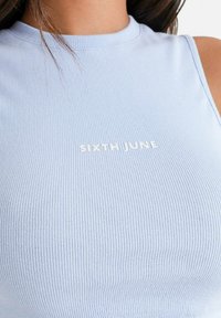 Top sin mangas de color azul claro con textura acanalada. Presenta un cuello redondo y el logo blanco "SIXTH JUNE" en el frente.