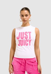 Top bianco senza maniche con la scritta audace in rosa "JUST JUICY", abbinato a pantaloni joggers rosa. Tessuto liscio con un design aderente e dettagli minimi.