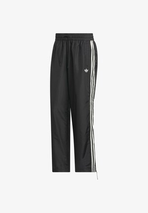 Sorte atletiske bukser med elastisk talje, hvide sidelister og lynlåse ved manchetterne. Fremstillet af letvægtsmateriale med et logo.