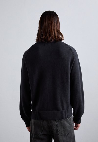 Dark gray knit sweater with a relaxed fit, raglan sleeves, and ribbed cuffs and hem. Textured fabric contrasts with smooth finish.