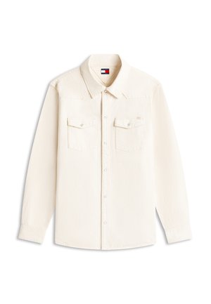 Chemise à manches longues écrue avec col, deux poches à rabat sur la poitrine avec boutons, et étiquette du logo Tommy Jeans à l'intérieur du col.