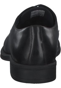 Čierne kožené formálne topánky s hladkým povrchom, okrúhlou špičkou a nízkym podpätkom. Obsahujú jemné švíky pozdĺž zadnej strany.