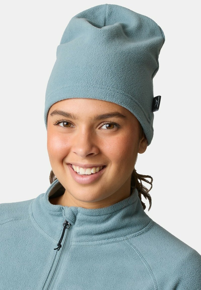 Vaaleansininen fleece-pipo, jossa on löysä malli. Päällä on ommeltu sauma ja sivussa pieni brändilogo. Pehmeä texture, rento istuvuus.