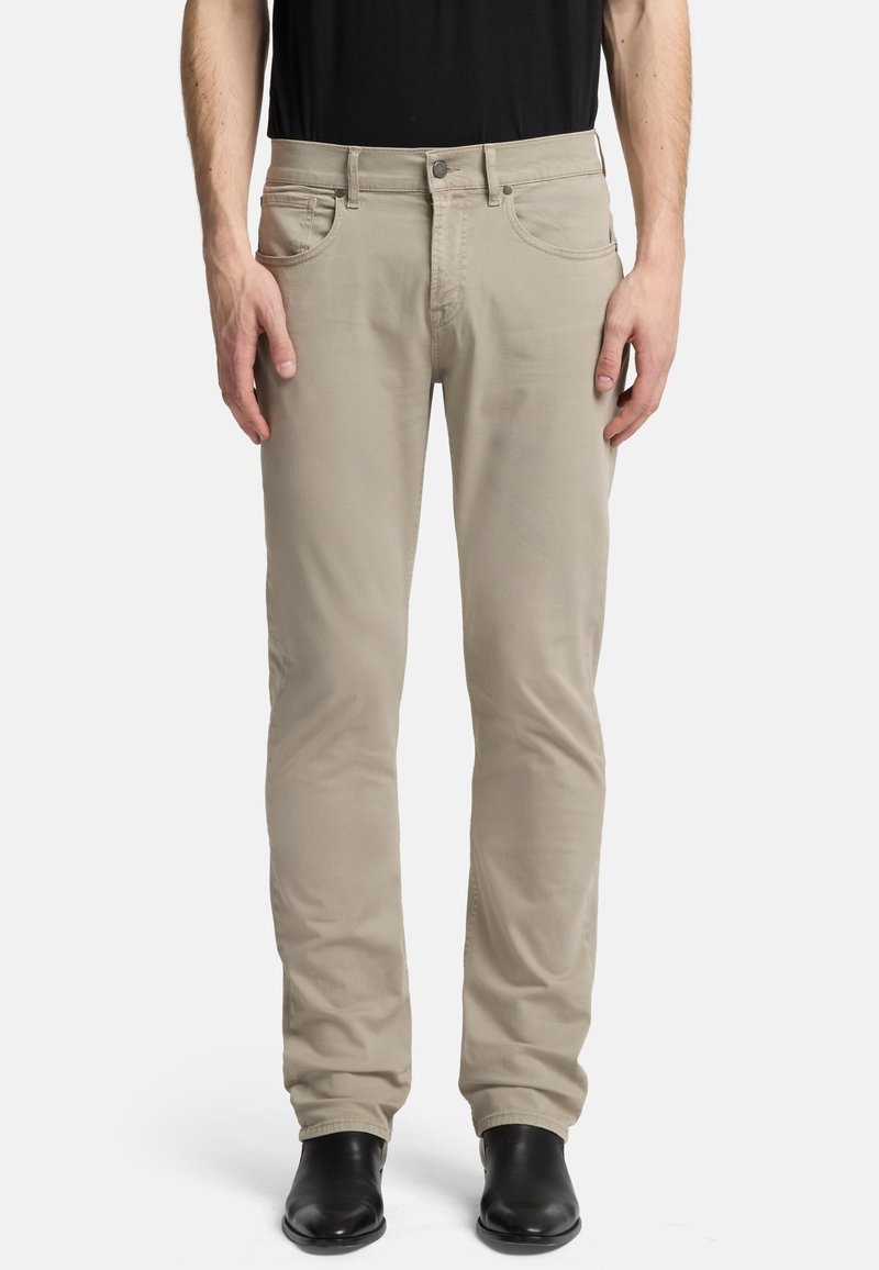 Beige avsmalnande byxor med flat front, fem fickor och blixtlås. Tillverkade av bomull, med en slät textur och minimalistisk design.