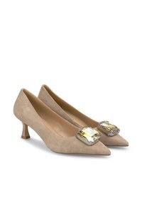 Escarpins en suede beige avec un bout pointu et un petit talon, ornés d'un grand bijou clair et jaune sur le devant.