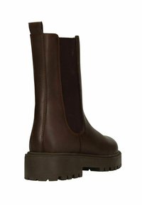 Bruine leren enkellaars met elastische zijkanten, een dikke rubberen zool en gestikte details, ontworpen voor duurzaamheid en comfort.