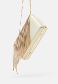 Metaliczna złota kopertówka z łańcuszkowym paskiem, ozdobiona frędzlami z mniejszych metalicznych koralików, o smukłym, prostokątnym kształcie i teksturowanym wykończeniu.