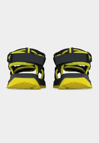 Ζευγάρι μαύρων και κίτρινων αθλητικών σανδαλιών, ορατά από πίσω, με ρυθμιζόμενους ιμάντες και υφασμένες κίτρινες σόλες.