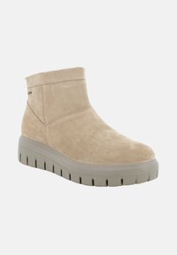 Stivale alla caviglia in suede beige con punta arrotondata e collare imbottito. Presenta una suola in gomma grigia spessa con scanalature profonde per una maggiore aderenza.