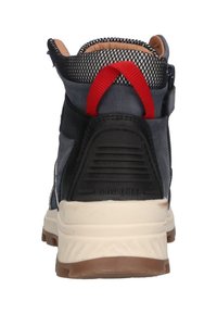 Grijze hoge sneaker met een zwarte mesh kraag, rode trekknoop, gestructureerde zwarte hak en een cream- en bruine rubberen zool.