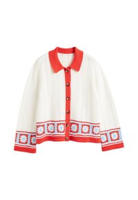 Witte gebreide cardigan met een rode kraag, knoopsluiting en decoratieve bloemenpatronen in blauw en rood aan de onderkant en op de mouwen.
