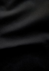 Black fabric with a smooth, matte texture, featuring subtle folds and a consistent weave pattern throughout the surface.