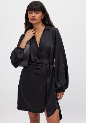 Black satin wrap dress with long balloon sleeves, deep V-neck, and gathered detail at the waist. Smooth texture and high slit accent.