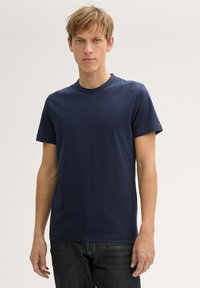 T-shirt a maniche corte di colore blu navy realizzato in tessuto morbido con scollatura a girocollo. Vestibilità classica con dettagli minimi e una texture liscia.