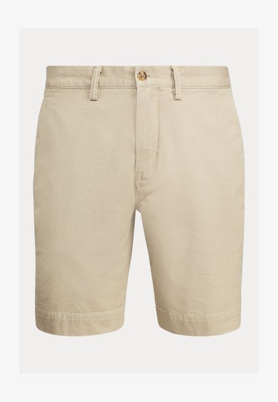 Calções de algodão beige com uma textura suave, fechamento com botão, passantes para cinto e bainha cosida. Apresenta um design clássico e ajustado.