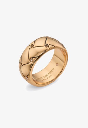 Anello in tono oro con un design intrecciato, caratterizzato da piccole pietre chiare incastonate nel motivo. Superficie liscia e lucida con il nome del marchio inciso all'interno.