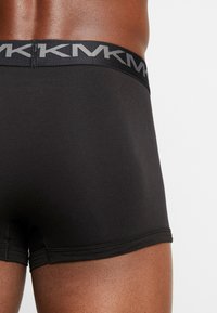 Mustat puuvillaiset boxershortsit, joissa on yhteensopiva joustava vyötärö, jossa on toistuva logo. Pehmeä rakenne, lähellä vartaloa istuva leikkaus.