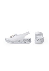 Weiße Leder-Slingback-Schuhe mit einer gesprenkelten grauen Außensohle und einer dekorativen Schnalle im oberen Bereich. Das offene Zehendesign verbessert die Atmungsaktivität.