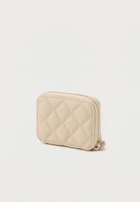 Δερμάτινο πορτοφόλι σε μπεζ χρώμα με καπιτονέ σχέδιο, με κλείσιμο με φερμουάρ, ορθογώνιο σχήμα και διακριτή υφή. Διαθέτει σχέδια διαμαντιών και στρογγυλεμένες γωνίες.